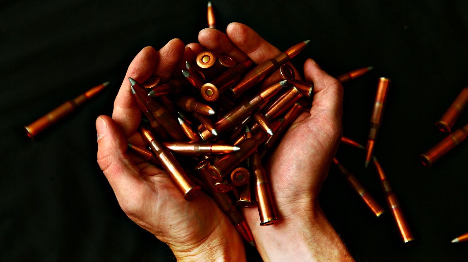 Hands holding a large amount of high powered rifle ammunition | Bulk Ammo | Budget Reloading Supplies | Featured