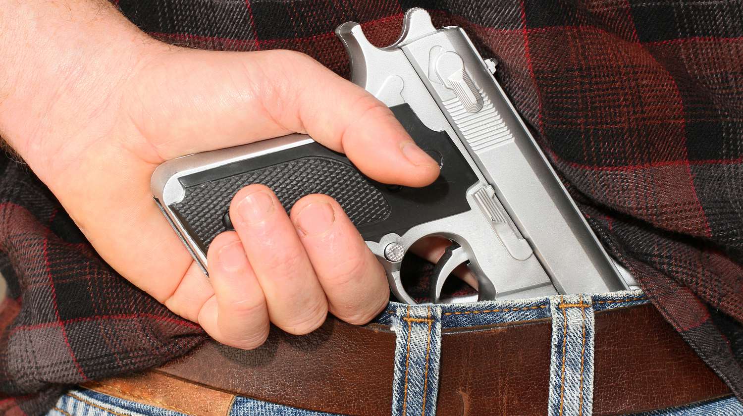 Pistol concealed in a man's waistband | No-Permit Concealed Carry Now Allowed In Maine | Featured