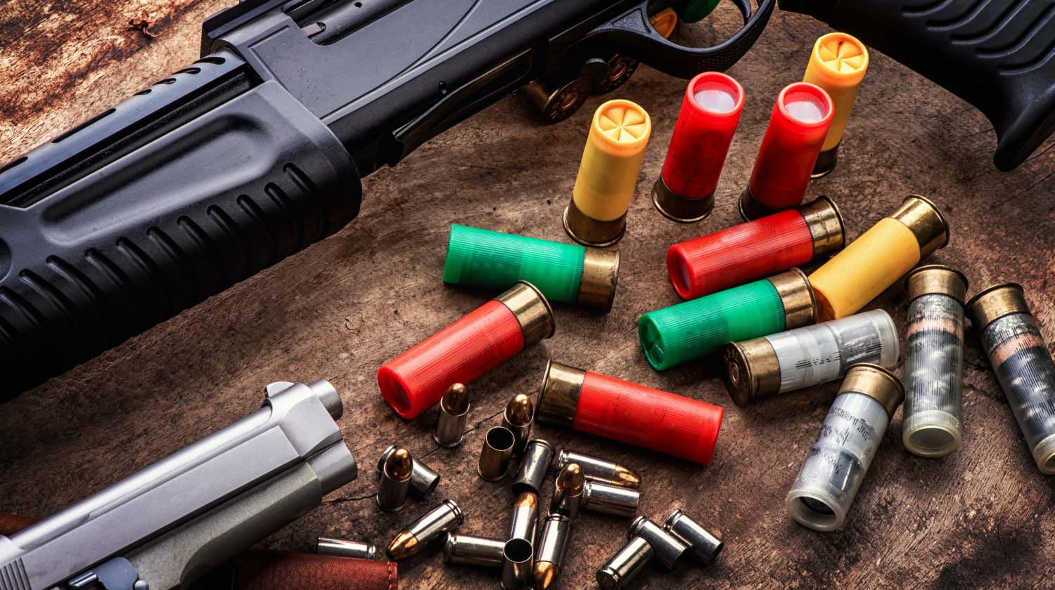 Weapons and military equipment. 9 mm pistol gun bullets and 12 gauge shotgun | Home Defense Guns | Shotgun vs. Handgun | Featured