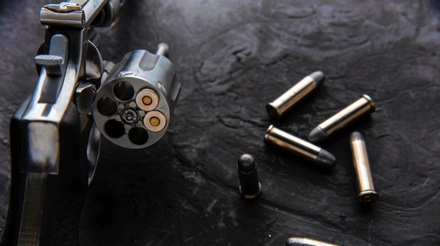 Gun with ammunition on dark background | Bringing Gun To The Gym: Why And How To Concealed Carry At The Gym | Featured