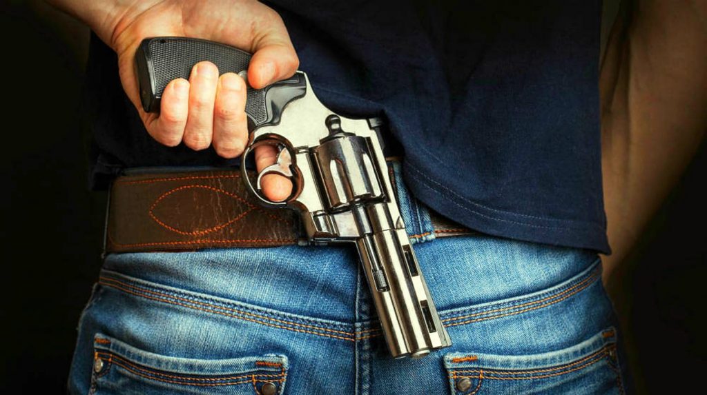 Feature | Gun in a man's back | The Best Revolver for Concealed Carry Handguns | Top Handguns