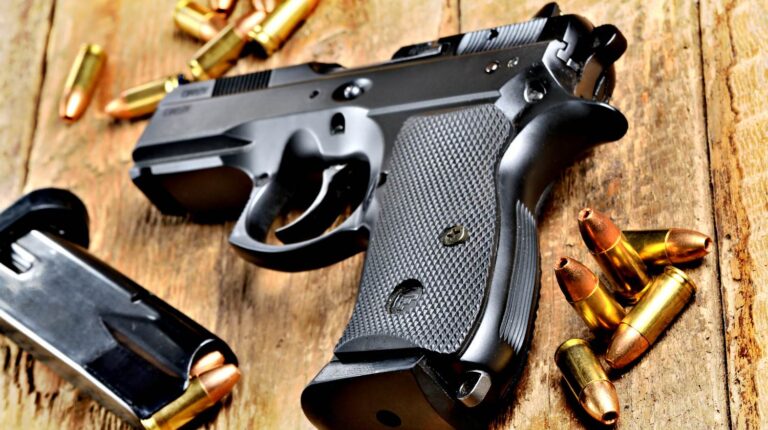 Feature | 9mm pistol, bullets and magazine on old wooden table | Handgun Reviews: The Taurus PT92