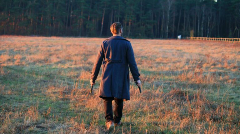 Feature | Man standing in front of green leafed trees | Stupid People With Guns: How NOT to Handle a Firearm