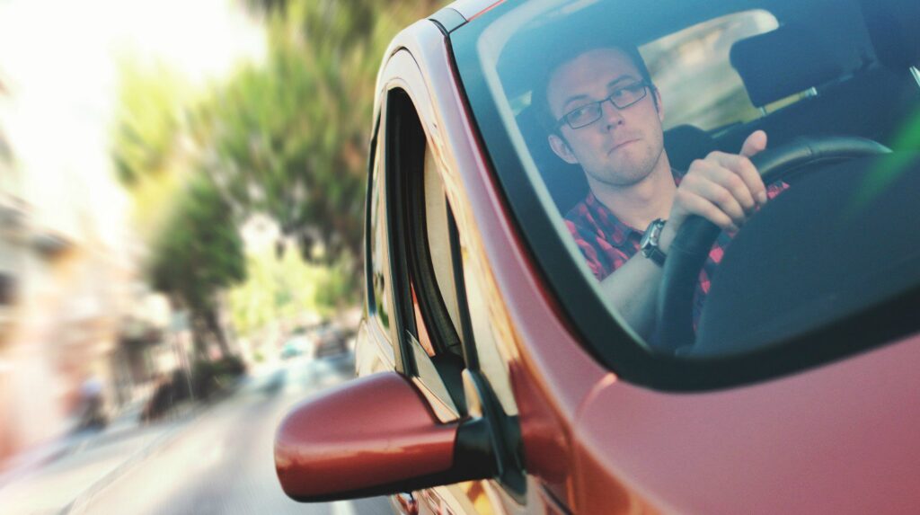 Feature | Man driving red vehicle | Interstate Driving While Carrying A Firearm: What You Need to Know