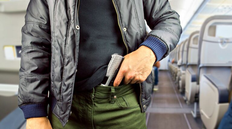 Featured | Closeup of an armed man in a commercial airplane | How To Fly With A Firearm