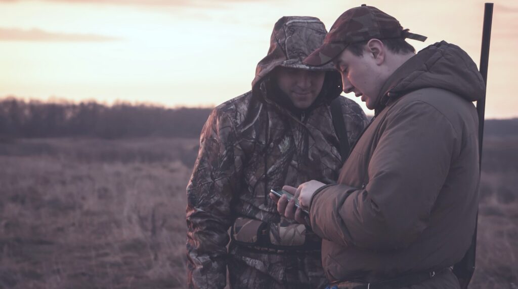 hunters using their smartphone | The Best Free Smartphone Apps For Your Firearms | free smartphone apps | phone app | Featured