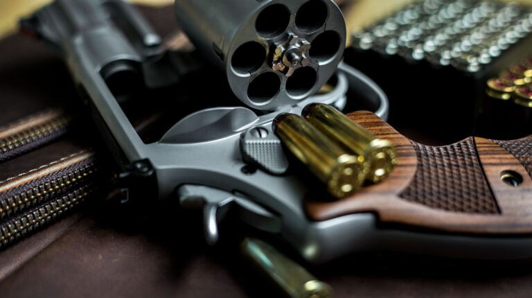 Revolver .44 magnum gun with grain bullet on leather background | Double Action Revolver An Introduction | Featured