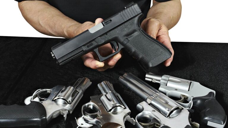 Salesman selling pistols and revolver assorted firearms for sale at gun show | The Gun Show Loophole Explained | Featured