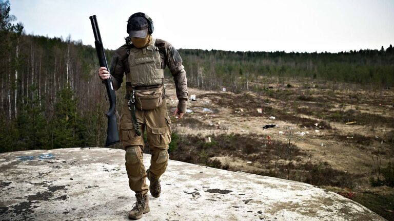 Young militarist man in army uniform with tactical vest | The Tactical Shotgun Scabbard By Beez Combat Systems | Featured